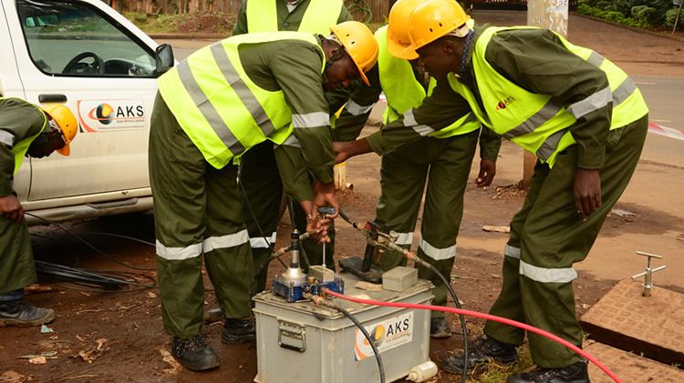 AKS technicians commissioning equipment beside an AKS-branded vehicle